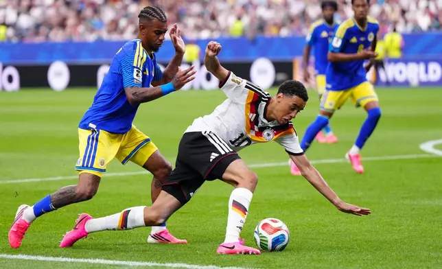 Germany's Jamal Musiala falls to the ground in front of Curaçao's Juninho Bacuna during the World Cup Group E soccer match between Germany and Curacao in Houston, Sunday, June 14, 2026. (AP Photo/Karen Warren)
