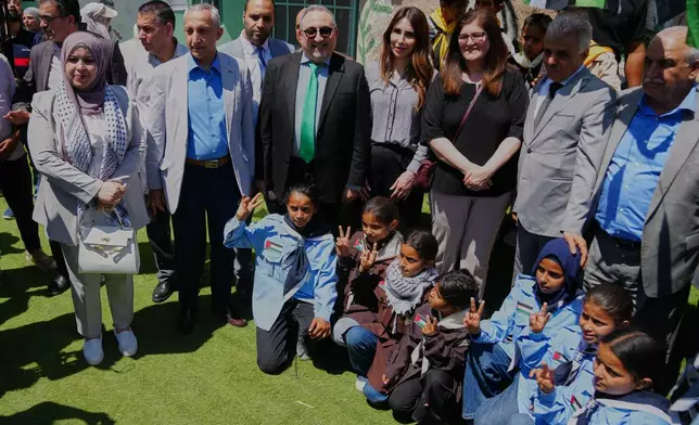 Palestinian officials and foreign diplomats take a photo with school children during their field tour in the West Bank Bedouin hamlets of Khan al-Ahmar, Wednesday, June 10, 2026. (AP Photo/Mahmoud Illean)