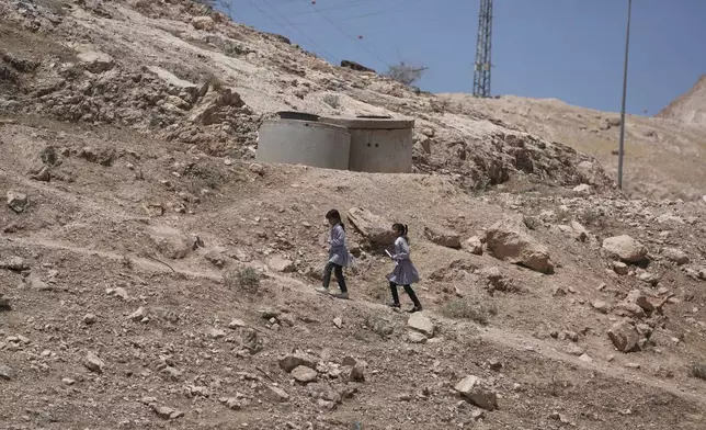 Palestinian students walk on their way home after receiving their year end reports from school, in the West Bank Bedouin hamlets of Khan al-Ahmar, Wednesday, June 10, 2026. (AP Photo/Mahmoud Illean)