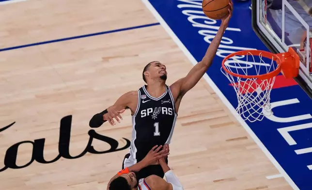 San Antonio Spurs forward Victor Wembanyama (1) pulls down a rebound over New York Knicks center Karl-Anthony Towns (32) during Game 3 of the NBA Finals basketball series, Monday, June 8, 2026, in New York. (AP Photo/Yuki Iwamura)
