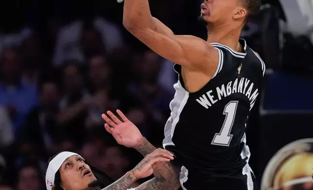 San Antonio Spurs forward Victor Wembanyama (1) passes as New York Knicks guard Jordan Clarkson defends during the first half of Game 3 of the NBA Finals basketball series, Monday, June 8, 2026, in New York. (AP Photo/Ross D. Franklin)