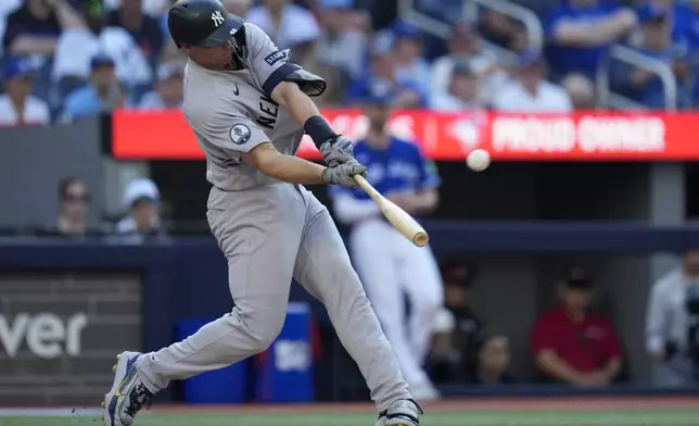 New York Yankees' Paul Goldschmidt hits a two-run home run against the Toronto Blue Jays during the ninth inning of a baseball game in Toronto, Saturday, June 13, 2026. (Frank Gunn/The Canadian Press via AP)