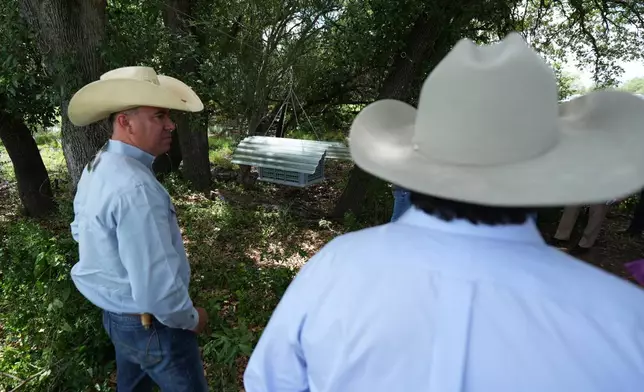 Rangers and land owners view a sterile fly dispersal station placed by the U.S. Department of Agriculture to combat the spread of the New World screwworm fly on grounds of a ranch near La Pryor, Texas, Thursday, June 11, 2026. (AP Photo/Eric Gay)