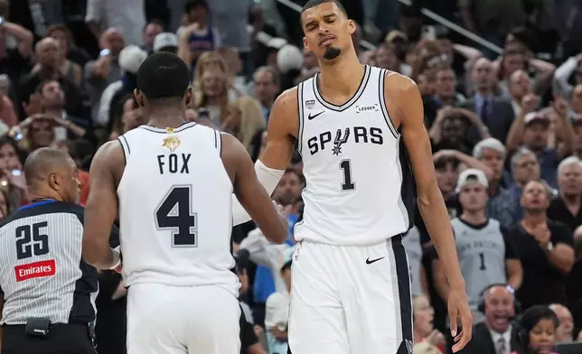 San Antonio Spurs forward Victor Wembanyama (1) and guard De'aaron Fox (4) reacts after a foul call during the second half of Game 2 of the NBA Finals basketball series against the New York Knicks, Friday, June 5, 2026, in San Antonio. (AP Photo/Eric Gay)