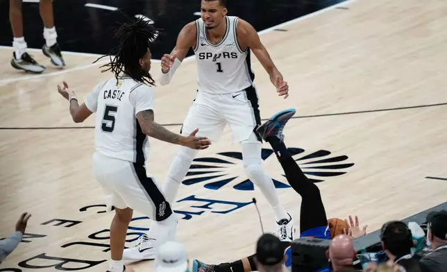 San Antonio Spurs forward Victor Wembanyama (1) and guard Stephon Castle (5) react as New York Knicks guard Jalen Brunson falls out of bounds during the second half of Game 2 of the NBA Finals basketball series, Friday, June 5, 2026, in San Antonio. (AP Photo/David J. Phillip)