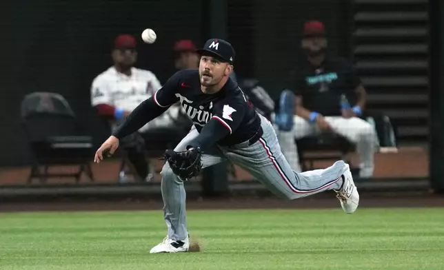 Minnesota Twins left fielder Trevor Larnach makes a diving catch on a ball hit by Arizona Diamondbacks' Geraldo Perdomo in the second inning of a baseball game, Sunday, June 21, 2026, in Phoenix. (AP Photo/Rick Scuteri)