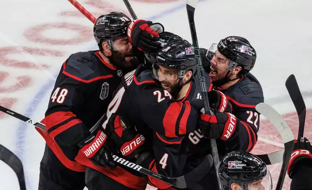 Carolina Hurricanes' Jordan Martinook (48), Seth Jarvis (24), Shayne Gostisbehere (4), and Logan Stankoven (22) ceelbrate after Jarvis scored the game-winning goal against against the Vegas Golden Knights in overtime of Game 2 of the NHL hockey Stanley Cup Final series in Raleigh, N.C., Thursday, June 4, 2026. (AP Photo/Ben McKeown)