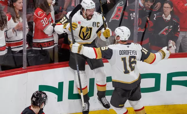 Vegas Golden Knights' Mark Stone (61) celebrates with Pavel Dorofeyev (16) after scoring against the Carolina Hurricanes to tie in the third period of Game 2 of the NHL hockey Stanley Cup Final series in Raleigh, N.C., Thursday, June 4, 2026. (AP Photo/Ben McKeown)
