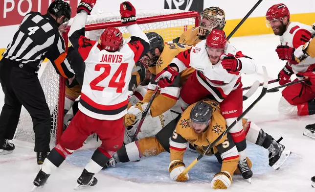 Carolina Hurricanes right wing Andrei Svechnikov (37) celebrates his goal with right wing Seth Jarvis (24) and center Jordan Staal (11) as he steps over Vegas Golden Knights defenseman Jeremy Lauzon (5) during the third period in Game 3 of the NHL hockey Stanley Cup Final series Saturday, June 6, 2026, in Las Vegas. (AP Photo/Candice Ward)