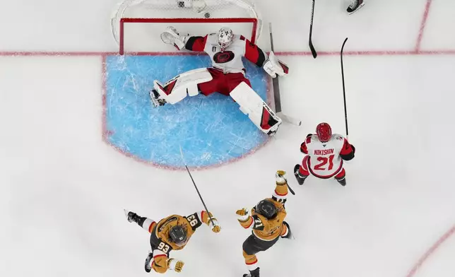 Vegas Golden Knights center William Karlsson (71) and Vegas Golden Knights right wing Mitch Marner (93) celebrate after Vegas Golden Knights defenseman Shea Theodore scored against Carolina Hurricanes goaltender Brandon Bussi (32) during the second overtime in Game 3 of the NHL hockey Stanley Cup Final series, Saturday, June 6, 2026, in Las Vegas. (AP Photo/John Locher)