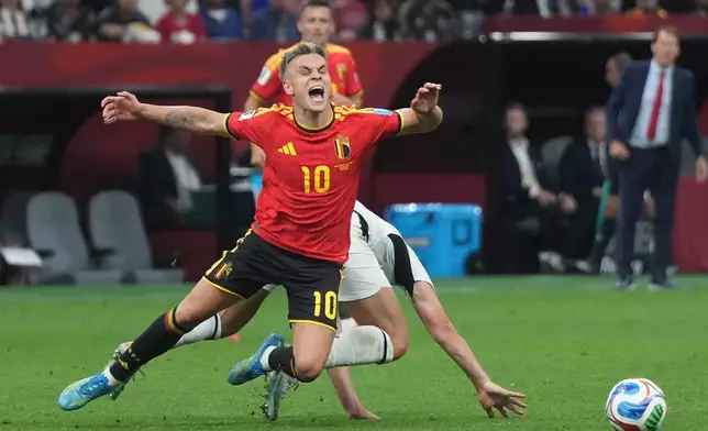 Belgium's Leandro Trossard (10) is upended by New Zealand's Liberato Cacace (13) during the second half of their World Cup Group G soccer match in Vancouver, British Columbia, Friday, June 26, 2026. (Darryl Dyck/The Canadian Press via AP)