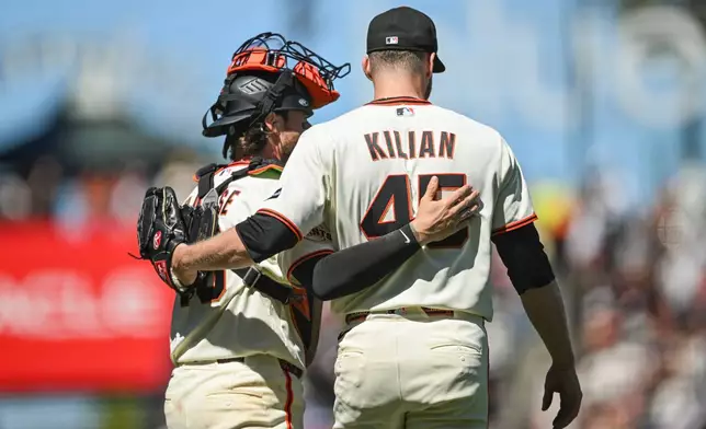 San Francisco Giants' Eric Haase, left, and Caleb Kilian, right, hug after their team defeated the Atlanta Braves in a baseball game, Sunday, June 28, 2026, in San Francisco (AP Photo/Justine Willard)