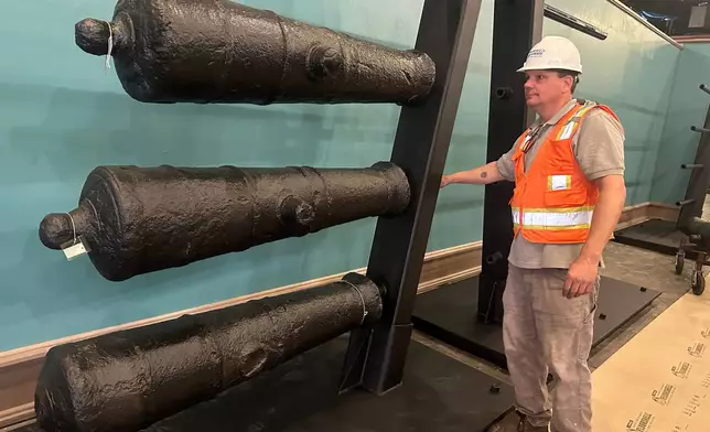 Terry Koeller inspects cannons, which sunk to the bottom of the Savannah River during the American Revolution, on a rack at the Savannah History Museum in Savannah, Ga., on Wednesday, June 3, 2026. (AP Photo/Russ Bynum)