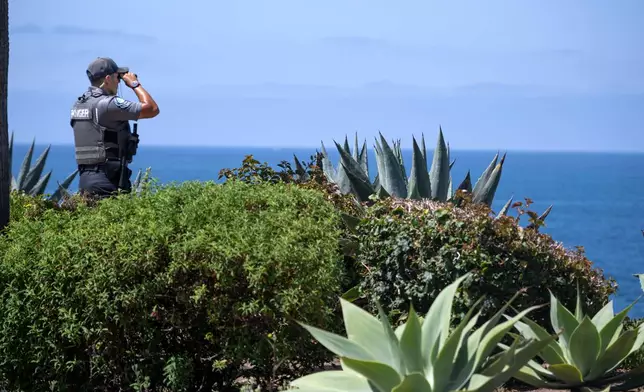 A Park Ranger scans the horizon on Wednesday, June 10, 2026, on Laguna Beach, Calif., near where a child was swept out to sea Tuesday. (Mindy Schauer/The Orange County Register via AP)