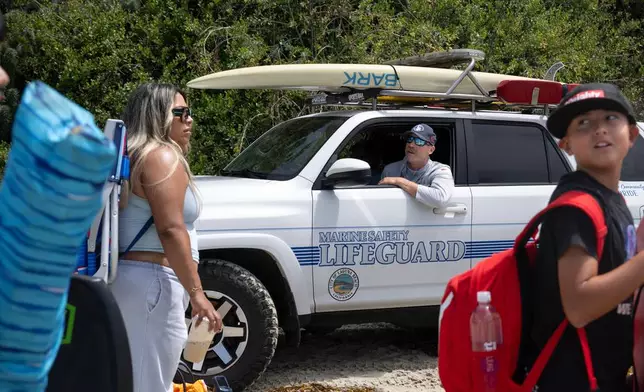 Laguna Beach Marine Safety Officer Avery Wickham breaks the news to beach-goers that they will not be allowed into the water because of dangerous conditions at the beach near Montage Resort on Wednesday, June 10, 2026, Laguna Beach, Calif. (Mindy Schauer/The Orange County Register via AP)