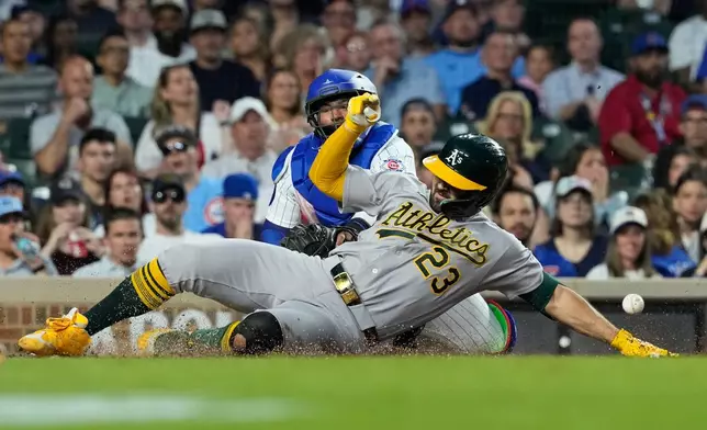 Athletics' Shea Langeliers (23) slides into home after hitting a two-run inside-the-park home run as Chicago Cubs catcher Moisés Ballesteros waits for the ball during the sixth inning of a baseball game against the Chicago Cubs in Chicago, Thursday, June 4, 2026. (AP Photo/Nam Y. Huh)