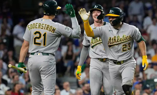 Athletics' Shea Langeliers (23), celebrates with Tyler Soderstrom (21) after hitting a two-run inside-the-park home run during the sixth inning of a baseball game against the Chicago Cubs in Chicago, Thursday, June 4, 2026. (AP Photo/Nam Y. Huh)