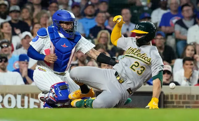 Athletics' Shea Langeliers, right, slides into home after hitting a two-run inside-the-park home run as Chicago Cubs catcher Moisés Ballesteros waits for the ball during the sixth inning of a baseball game against the Chicago Cubs in Chicago, Thursday, June 4, 2026. (AP Photo/Nam Y. Huh)