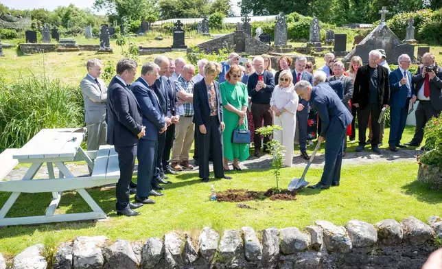 Canadian Prime Minister Mark Carney plants an oak tree during a visit to Aughagower, Ireland, Sunday, June 14, 2026. (Andrew Downes/PA via AP)