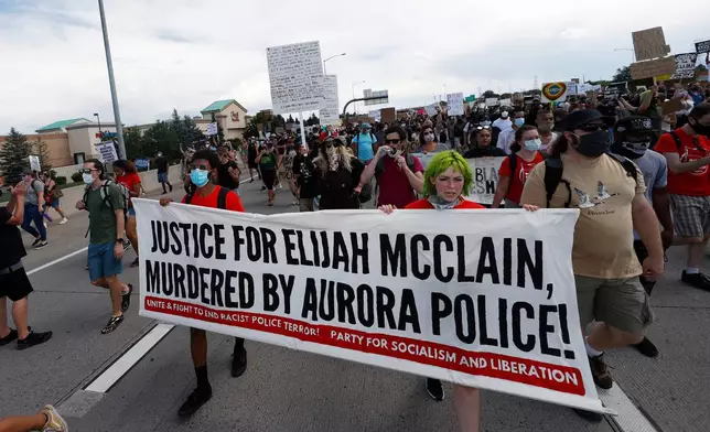 FILE - Demonstrators carry a banner while marching down Interstate 225 during a rally and march over the death of Elijah McClain, June 27, 2020, in Aurora, Colo. A trial for two of the officers charged for McClain's death is set to begin Friday, Sept. 15, 2023 with jury selection. (AP Photo/David Zalubowski, file)