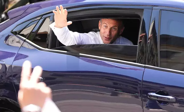 French President Emmanuel Macron waves from a car leaving after meeting security forces ahead of G7 summit in Evian-les-Bains, France, Monday, June 15, 2026. (AP Photo/Christophe Ena)
