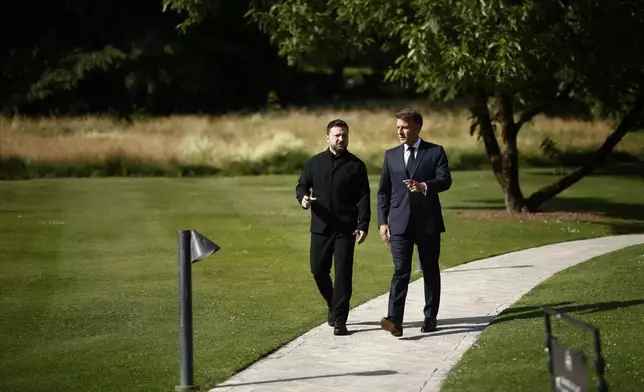 French President Emmanuel Macron, right, walks with Ukrainian President Volodymyr Zelenskyy at the Hotel Royal for the G7 Summit in Evian-les-Bains, France, Tuesday, June 16, 2026. (Yoan Valat/Pool Photo via AP)