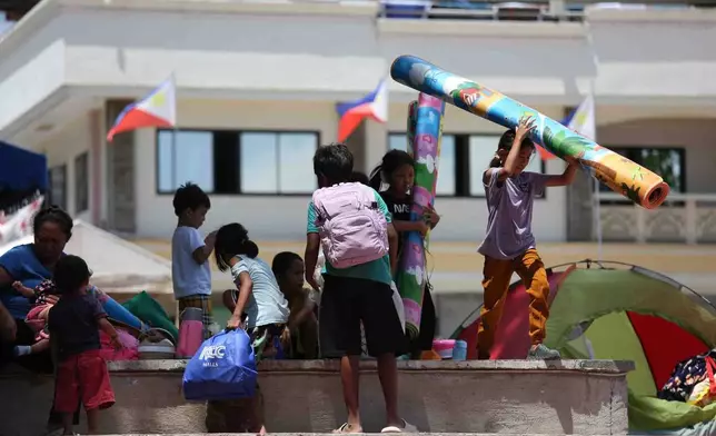 Residents take shelter in a field at a municipal hall in Sarangani province, Philippines, Wednesday, June 10, 2026. (AP Photo/Basilio Sepe)