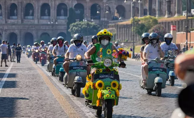 Vespa enthusiasts parade in front of the Colosseum during celebrations for the 80th anniversary of the Vespa scooter, in Rome, Saturday, June 27, 2026. (AP Photo/Alessandra Tarantino)
