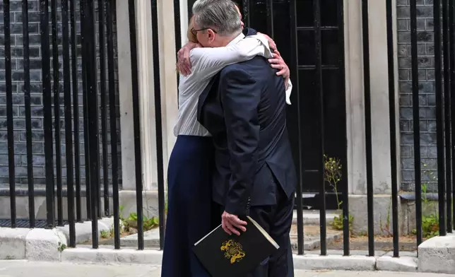 Britain's Prime Minister Keir Starmer hugs his wife Victoria after he announced his resignation outside 10 Downing Street in London, Monday, June 22, 2026.AP Photo/Thomas Krych)