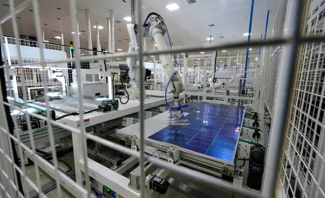 FILE - A robot places solar cells on a glass panel at a ReNew manufacturing plant on the outskirts of Jaipur, India, Aug. 21, 2025. (AP Photo/Manish Swarup, File)