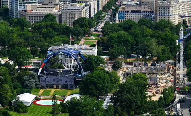 Workers continue building the stage for a future UFC fight on the South Lawn of the White House, left, Tuesday, June 9, 2026, in Washington, as work also continues on the construction of the ballroom, right. (AP Photo/Cliff Owen)
