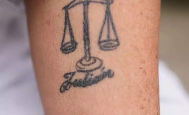 Blanca Nubia Monroy shows a tattoo with the name of her son, Julian Oviedo, who disappeared in 2008 and whose body was found months later in a clandestine grave, in Bogota, Colombia, Monday, June 1, 2026. (AP Photo/Matias Delacroix)