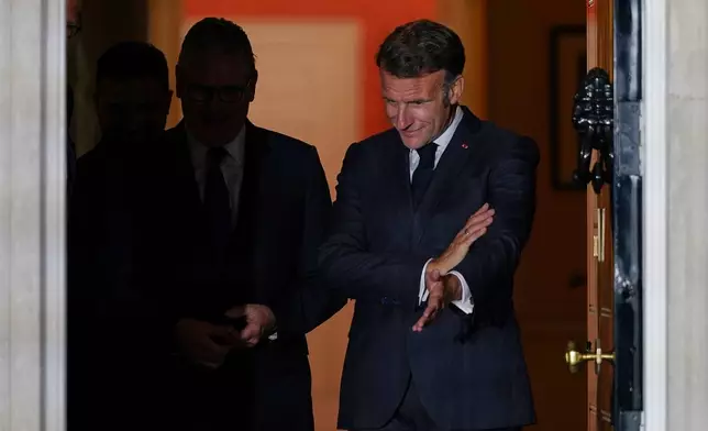 France's President Emmanuel Macron gestures to Britain's Prime Minister Keir Starmer as they walk out of 10 Downing Street before a meeting inside with the leaders of Germany and Ukraine, in London, Sunday, June 7, 2026. (AP Photo/Alberto Pezzali)