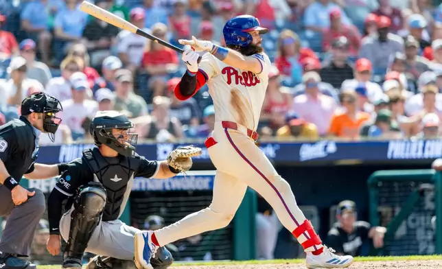 Philadelphia Phillies' Brandon Marsh, right, hits an RBI single in the sixth inning of a baseball game against the Chicago White Sox, Sunday, June 7, 2026, in Philadelphia. (AP Photo/Laurence Kesterson)