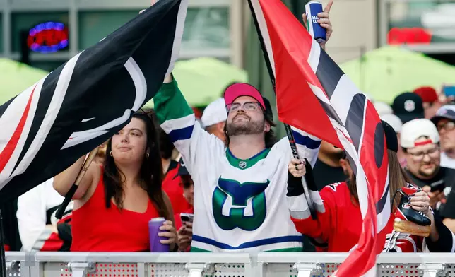 Carolina Hurricanes fans, Sue Allen, left, and Nick Skidmorein, who arrived at 5am to get a front row seat, wait for the start of the Stanley Cup Championship celebration in Raleigh, N.C., Saturday, June 20, 2026. (AP Photo/Karl DeBlaker)