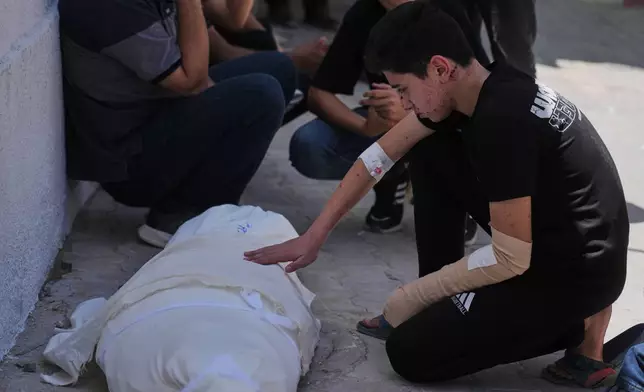 Omar Klaub, injured in an Israeli strike, mourns beside the body of his mother, Rana, who was killed in the same attack, during her funeral at Shifa Hospital in Gaza City, Thursday, June 4, 2026. (AP Photo/Jehad Alshrafi)