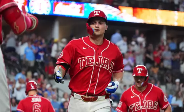 Texas Rangers' Corey Seager, center, jogs to the dugout after hitting a home run during the sixth inning of a baseball game against the Cleveland Guardians, Friday, June 5, 2026, in Arlington, Texas. (AP Photo/LM Otero)