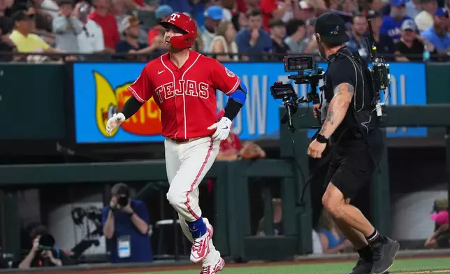 Texas Rangers' Kyle Higashioka, left, runs the bases after hitting a home run during the sixth inning of a baseball game against the Cleveland Guardians, Friday, June 5, 2026, in Arlington, Texas. (AP Photo/LM Otero)