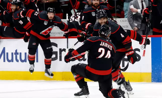Carolina Hurricanes' Seth Jarvis (24) celebrates after his winning goal with Shayne Gostisbehere (4) during the overtime period in Game 2 of the NHL hockey Stanley Cup Final series against the Vegas Golden Knights in Raleigh, N.C., Thursday, June 4, 2026. (AP Photo/Karl DeBlaker)