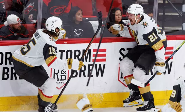 Vegas Golden Knights' Noah Hanifin (15) and Brett Howden (21) celebrate after a goal during the second period of Game 2 of the NHL hockey Stanley Cup Final series against the Carolina Hurricanes in Raleigh, N.C., Thursday, June 4, 2026. (AP Photo/Ben McKeown)