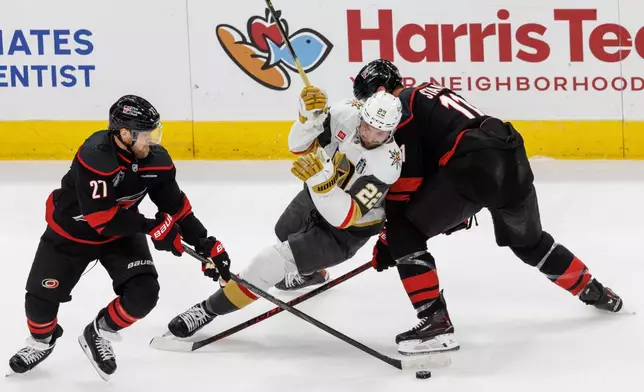 Carolina Hurricanes' Nikolaj Ehlers (27) and Jordan Staal (11) battle with Vegas Golden Knights' Cole Smith (22) for a puck during the third period of Game 1 of the NHL hockey Stanley Cup Final series in Raleigh, N.C., Tuesday, June 2, 2026. (AP Photo/Ben McKeown)