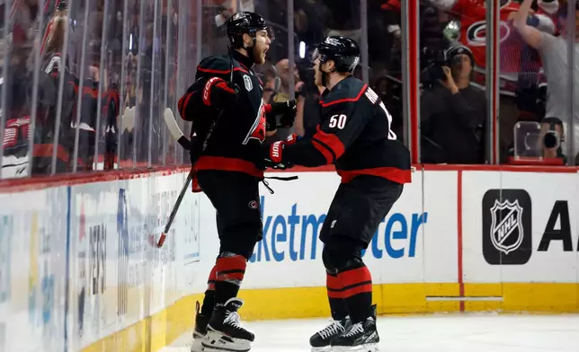 Carolina Hurricanes' Mark Jankowski, left, celebrates after his goal with Eric Robinson (50) during the third period in Game 2 of the NHL hockey Stanley Cup Final series against the Vegas Golden Knights in Raleigh, N.C., Thursday, June 4, 2026. (AP Photo/Karl DeBlaker)
