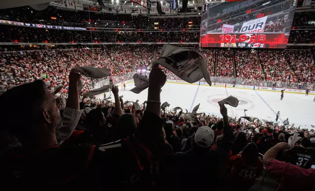 Fans at the Lenovo Center wave towels late in the third period in Game 1 of the NHL hockey Stanley Cup Final series between the Carolina Hurricanes and the Vegas Golden Knights in Raleigh, N.C., Tuesday, June 2, 2026. (AP Photo/Ben McKeown)