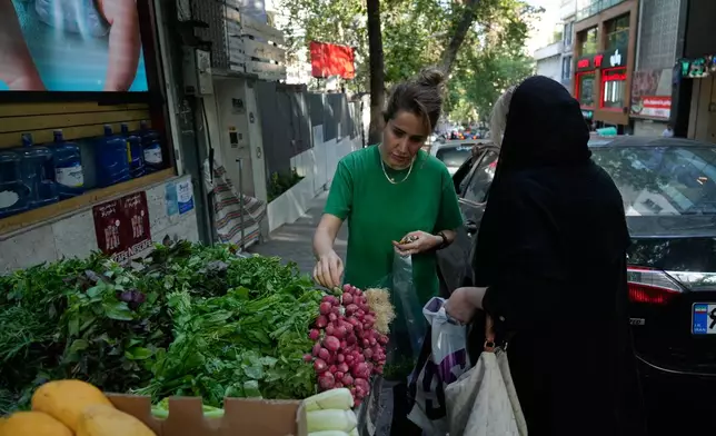 Women buy vegetables in northern Tehran, Iran, Wednesday, June 10, 2026. (AP Photo/Vahid Salemi)