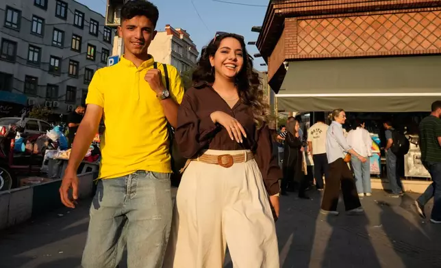 Joyful youngsters walk on a sidewalk in northern Tehran, Wednesday, June 10, 2026. (AP Photo/Vahid Salemi)