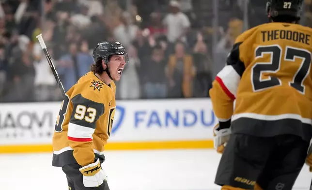 Vegas Golden Knights right wing Mitch Marner celebrates his goal with defenseman Shea Theodore, an own goal by the Carolina Hurricanes defenseman Sean Walker, during the second period in Game 3 of the NHL hockey Stanley Cup Final series Saturday, June 6, 2026, in Las Vegas. (AP Photo/John Locher)