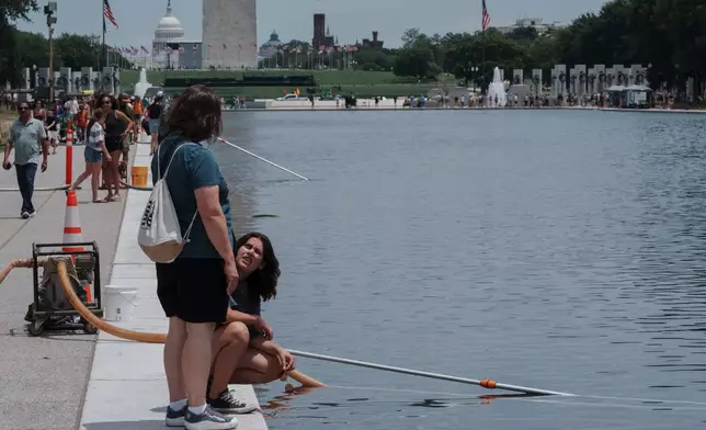 Visitors look at the Lincoln Memorial Reflecting Pool Sunday, June 21, 2026, on the National Mall in Washington. (AP Photo/Jon Elswick