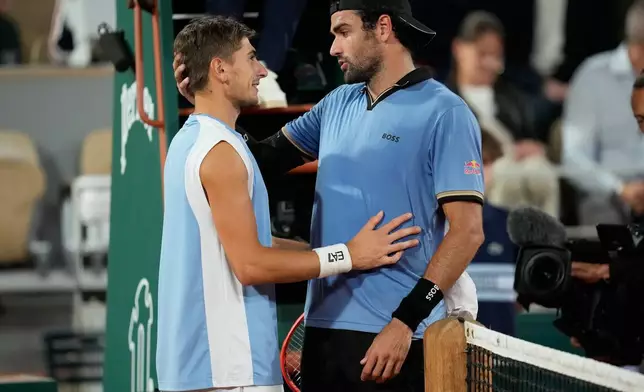 Italy's Matteo Arnaldi, left, talks to Italy's Matteo Berrettini who withdrw because of an injury during the quarterfinal tennis match at the French Open in Paris, Wednesday, June 3, 2026. (AP Photo/Christophe Ena)