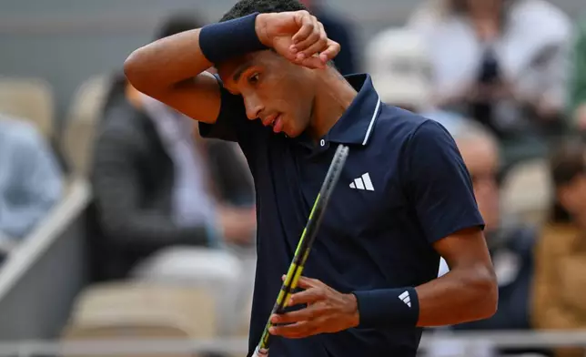 Canada's Felix Auger-Aliassimee wipes his face during the quarterfinal tennis match against Italy's Flavio Cobolli at the French Open in Paris, Wednesday, June 3, 2026. (AP Photo/Emma Da Silva)