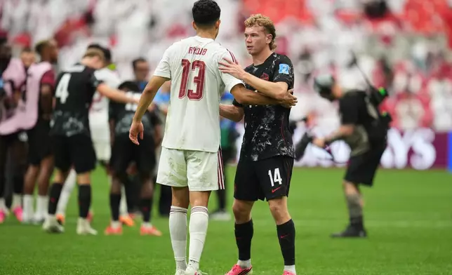 Qatar's Ayoub Aloui, left, and Canada's Jacob Shaffelburg embrace after Canada's victory in the World Cup Group B soccer match against Qatar in Vancouver, British Columbia, Thursday, June 18, 2026. (AP Photo/Abbie Parr)